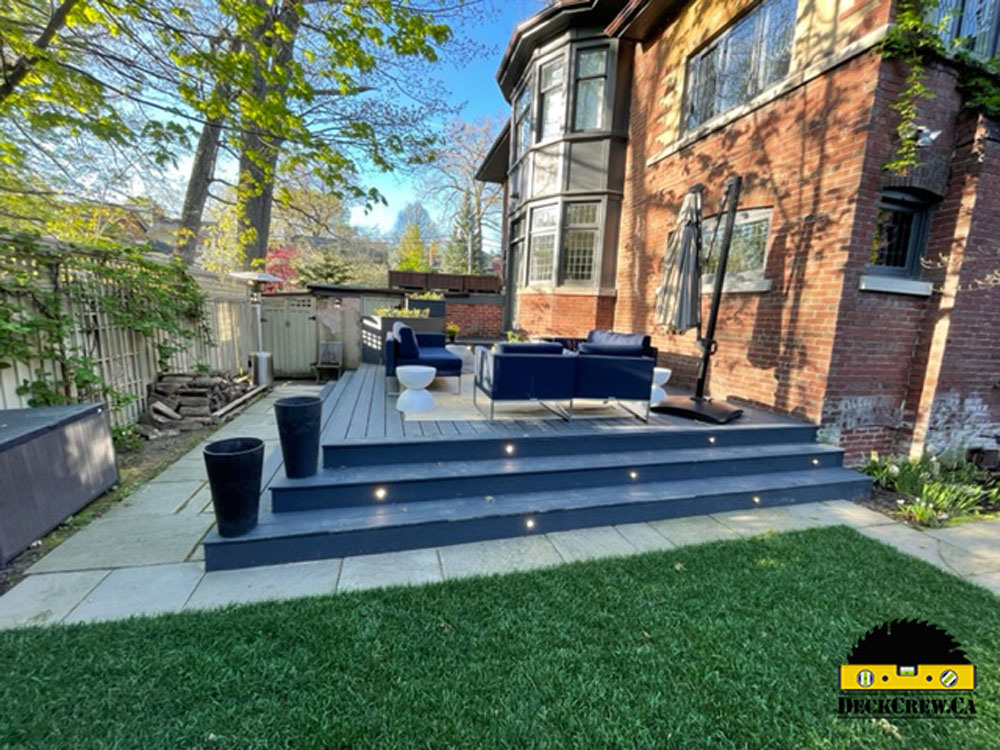 Grey composite deck with lights and furniture in the backyard in Toronto