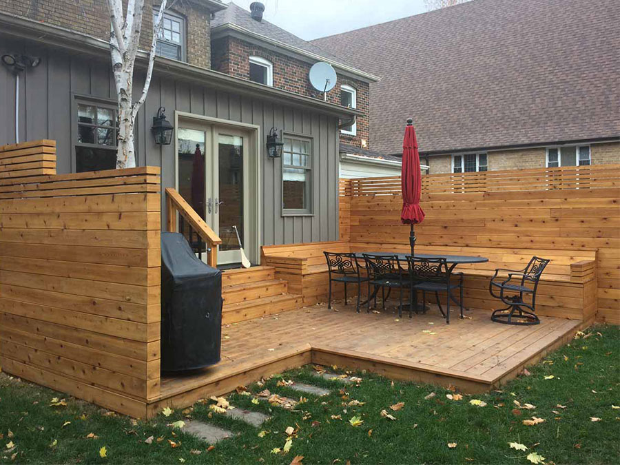 Cedar deck wth stairs and a sitting area in a back yard