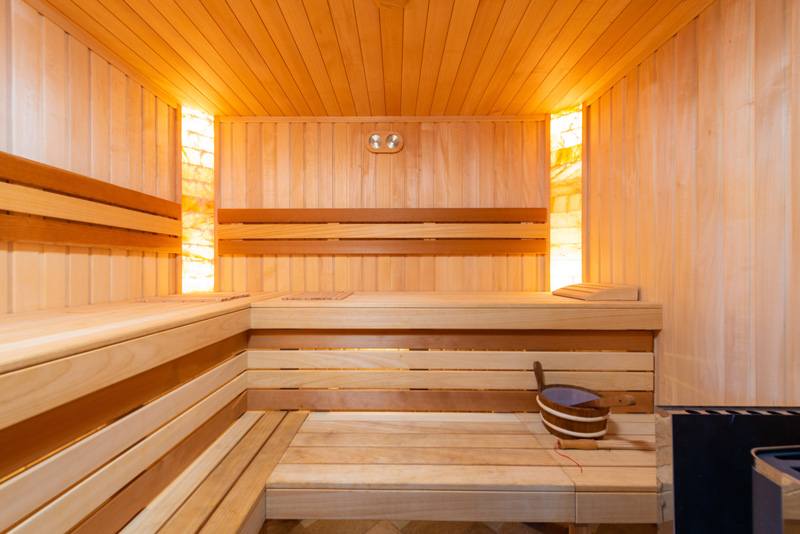 An interior of sauna room with benches and a water bowl