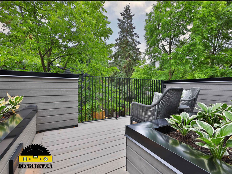 Grey-toned composite decking with planters and black caps