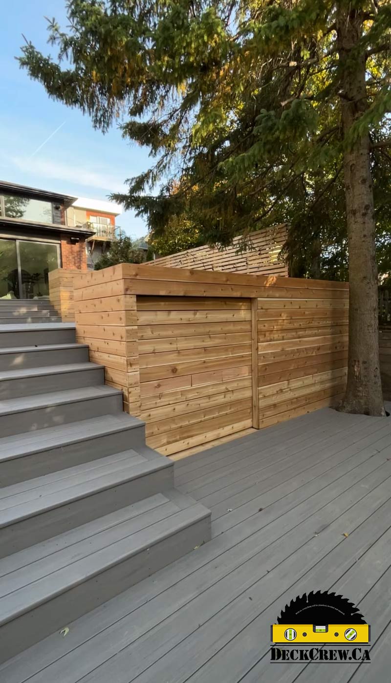 Grey composite stairs and a cedar shed