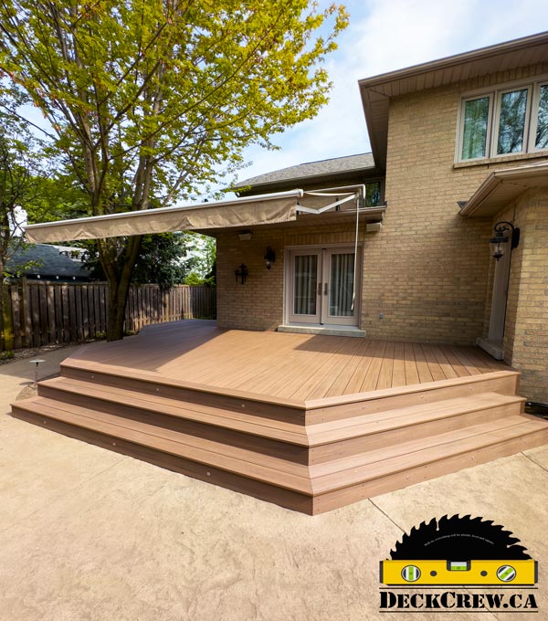 English Walnut deck with wide wraparound steps and angled corners beside a brick home in Etobicoke.